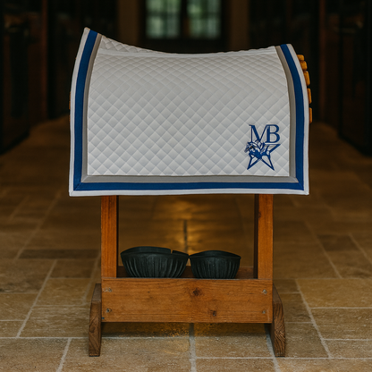 Saddle pad with a logo on a wooden stand in a stable setting